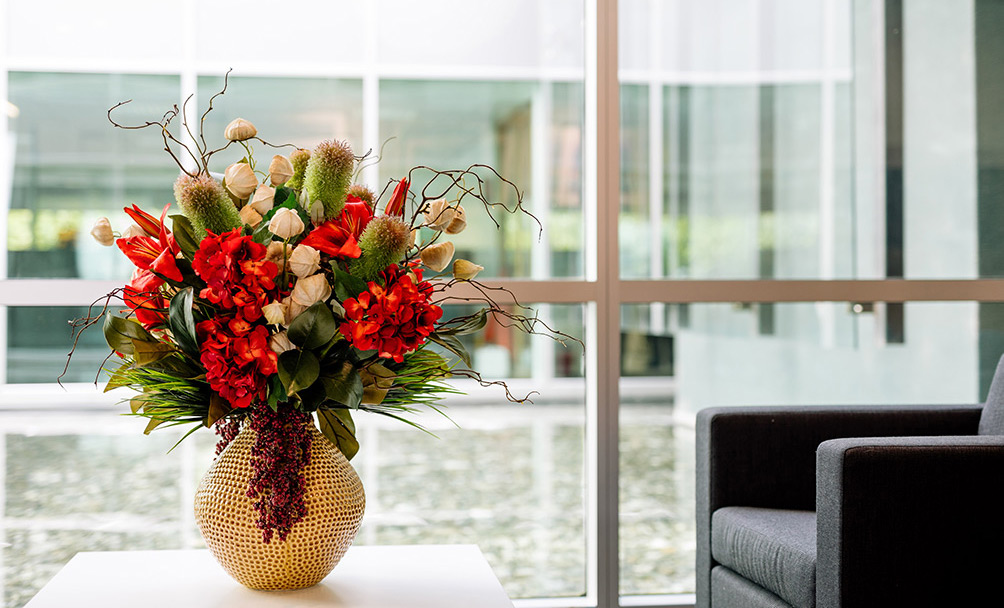 Modern artificial flower arrangement on coffee table in reception