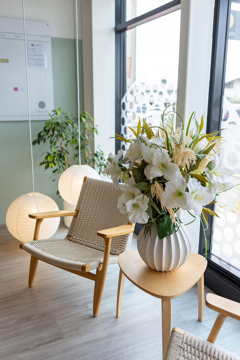 Modern artificial floral arrangement in waiting room with big white blooms